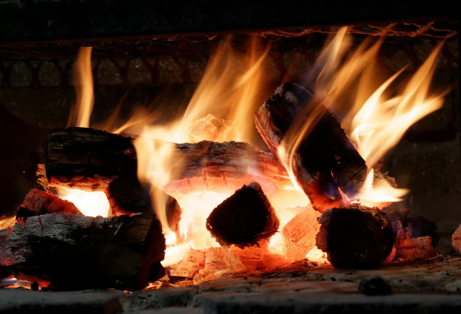 Close-up view of vivid flames and burning firewood in a cozy indoor fireplace.