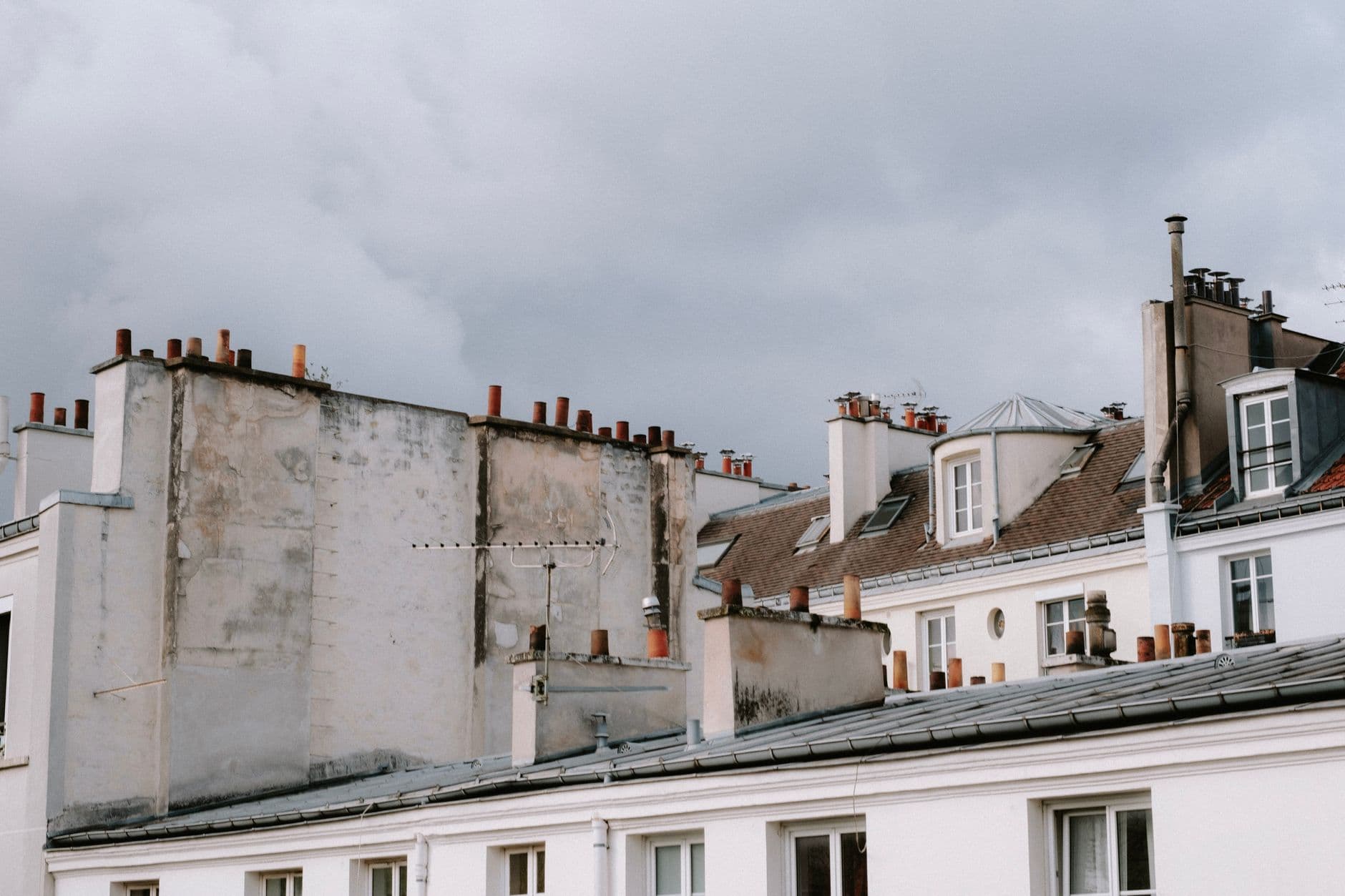 A serene view of urban rooftops under a gloomy sky, capturing city architecture.